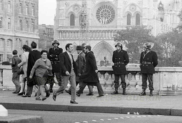 Juillet 1970 - Scne de rue - Passants sur le Petit Pont (cathdrale de Notre-Dame en arrire-plan) devant des gardes mobiles...